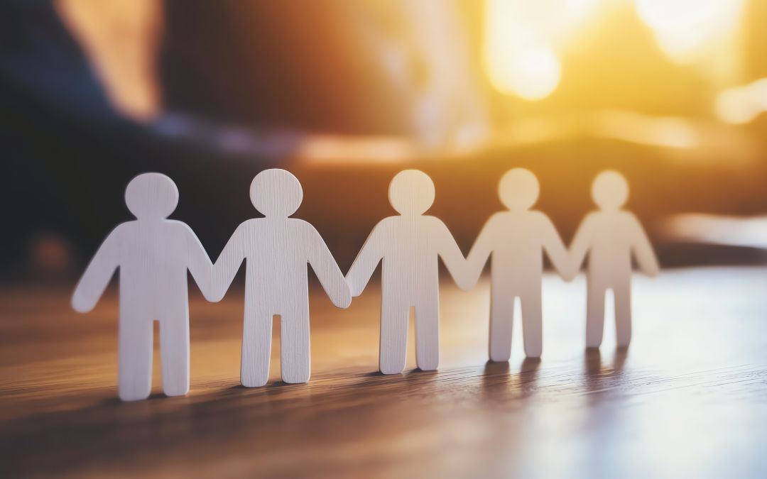 5 simple human cut outs in front of people's arms in the background